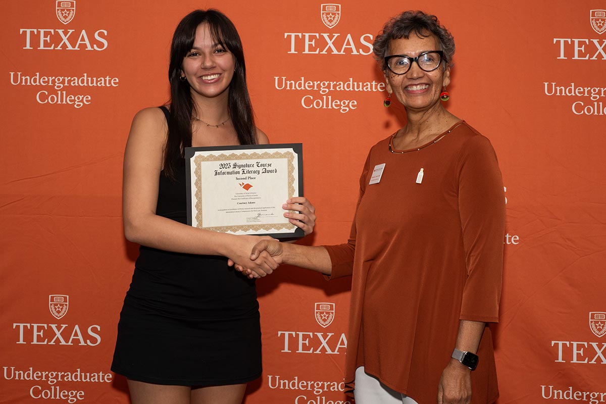 student being presented award by library director