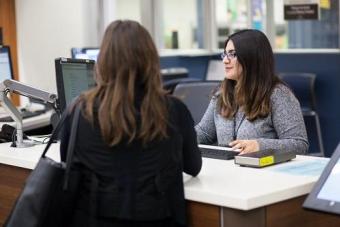 A student being helped by another person in front of a computer