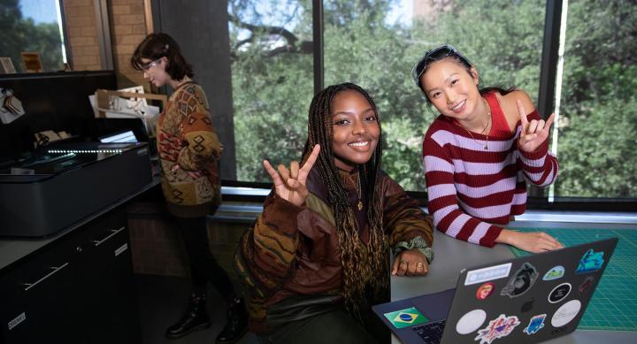 three students interacting at the Fine Arts Library foundry