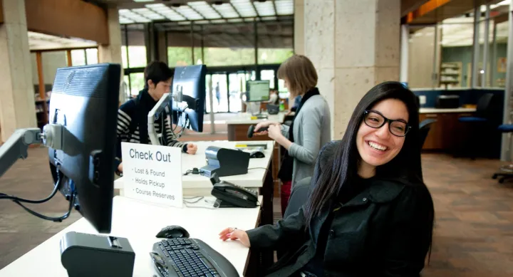 Person at circulation desk, smiling