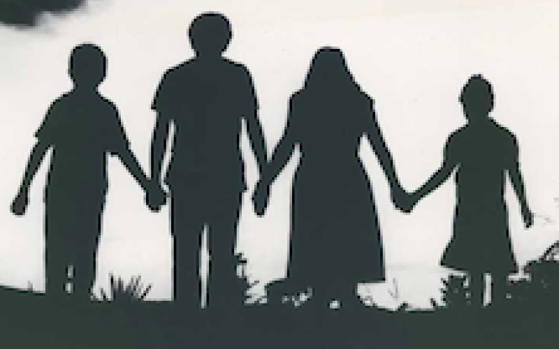 Four people walking in silhouette